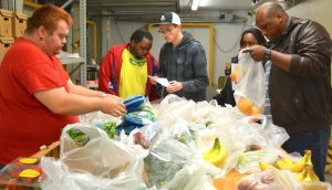 (Left to right) Jesse Lewis, James Watson, Kevin Roberts, Maria Poncy and Cimerion Watson, volunteers with EmployAbility, package NLaws at Home food items for St. Joseph